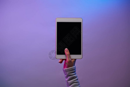 男人手的特写镜头与智能手机和空白的黑色屏幕在空白的紫色背景图片