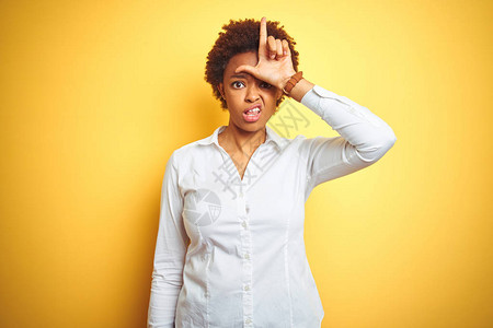 非洲女商业界人士在孤立的黄色背景中取笑前额有手指的人图片