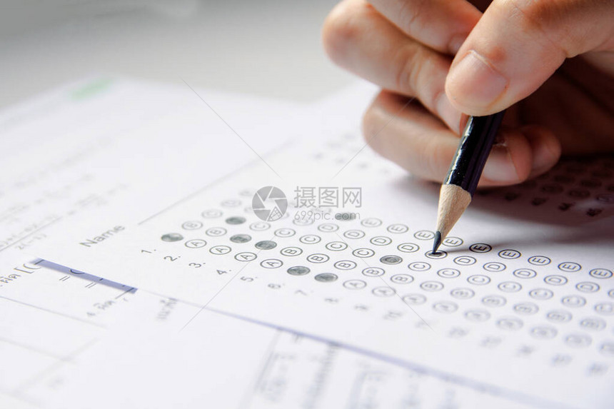 学生手持铅笔在答题纸和数学问题纸上书写选定的选项学生测试做考图片