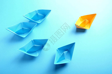 一个橙色的纸船和一组蓝色的蓝色小船图片