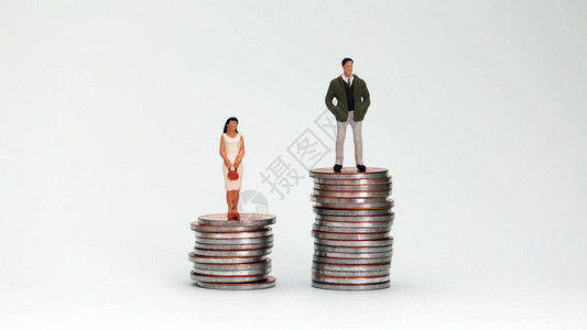 一个小型男人和女人站在一堆硬币上图片