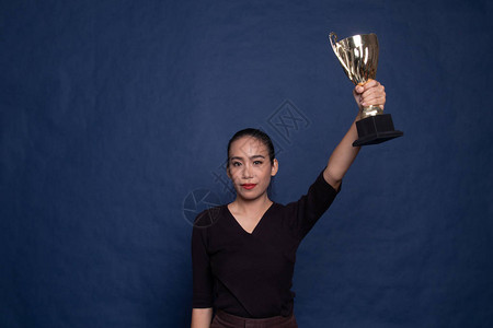 成功的年轻亚洲女子拿着蓝底奖图片