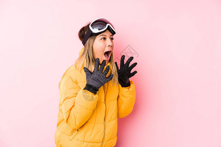 身穿粉红背景滑雪衣的年轻高加索妇女大声喊叫图片