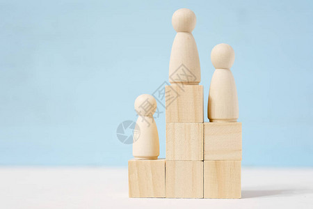 玩具立方体上的三个木制男子按等级排列图片