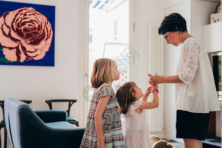 单身母亲与两个女儿一起在室内玩气球玩具游戏快乐周末活图片