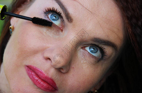黑发女人蓝眼睛在她长的睫毛上涂睫毛膏图片
