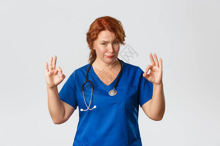 时髦可爱的中年红发女护士穿着磨砂膏图片
