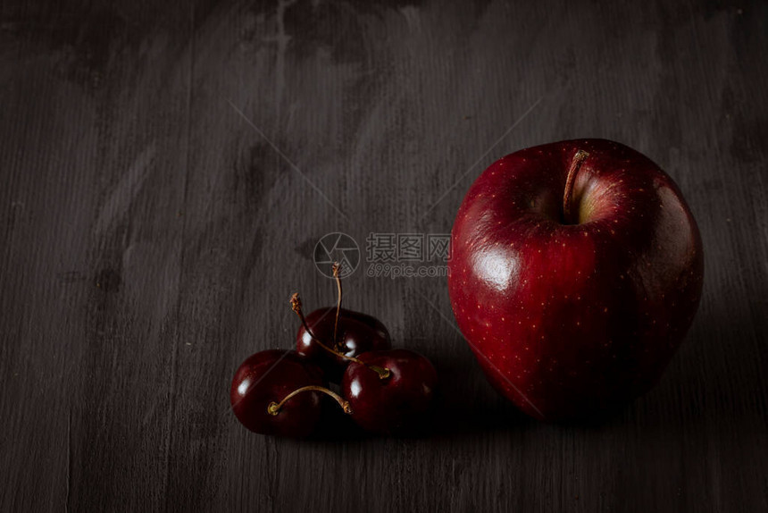 苹果加上古黑桌上的樱桃有文图片