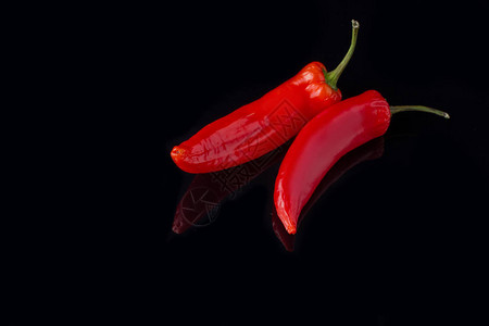 黑色背景中的新鲜红辣椒两个辣椒烹饪的辛辣配料图片