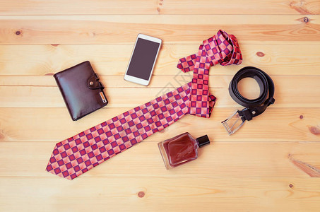 时髦的领带钱包智能手机香水和木制图片
