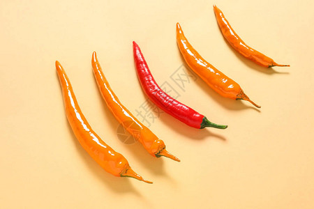 颜色背景中橙色辣椒中的红辣椒独特概念图片