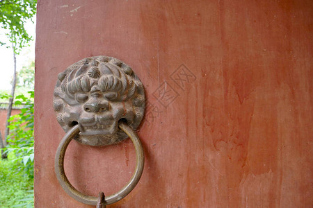 古老的红木门和金属狮子门环在宾图片