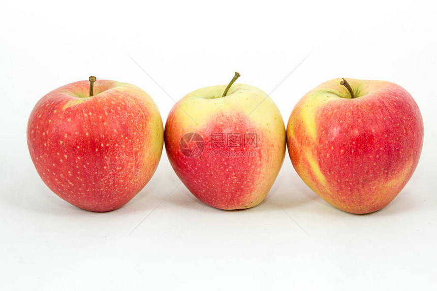 白色背景上的一排三个大红苹果图片