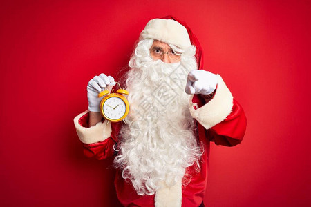 穿着圣诞老人服装的老人拿着闹钟图片