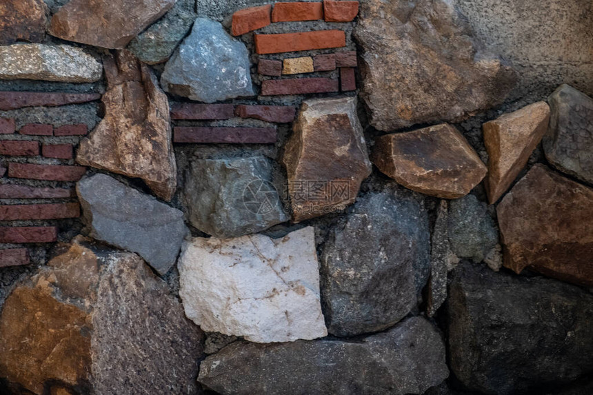 石头和砖块的马赛克墙壁由天然巨石和鹅卵石制成天然材料的纹理五颜六色的背景晴图片