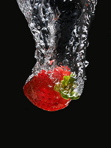 黑色背景中水的草莓图片