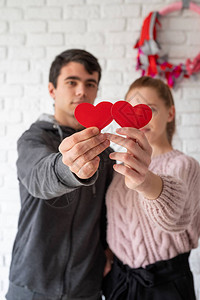 情人节概念年轻夫妇在白砖上穿图片