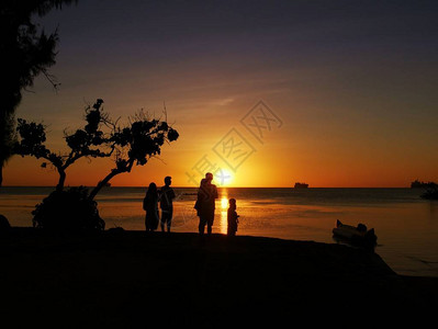 热带岛屿日落时站在海边图片