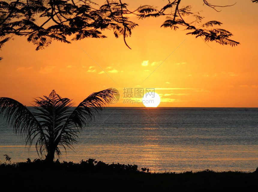 满圆的太阳在海水中落下被海滩上图片