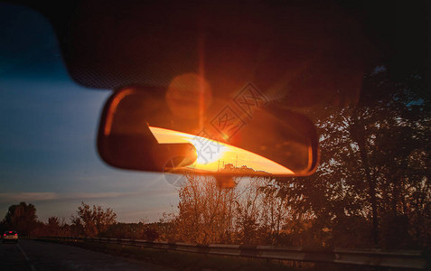 一辆汽车后视镜里一个沙龙里的日落图片