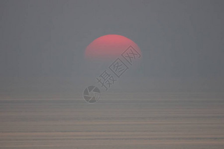 太阳落入大海被雾气吞没天空一片漆黑图片