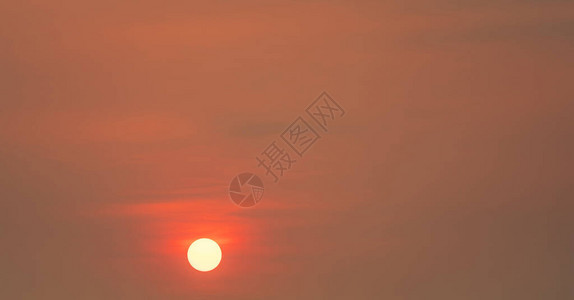 晚上圆大的太阳和红色的落日天空背景图片