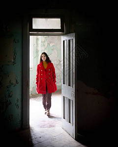 穿着红色衣的年轻美女走在一个废弃房间的图片