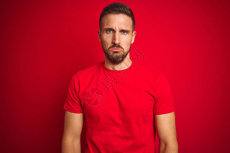 年轻英俊男子穿着临时T恤穿红色孤立背景的短袖圆领汗衫图片