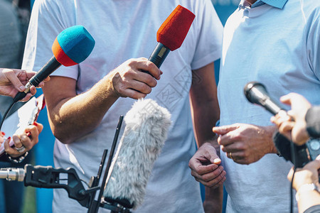 记者采访男用扬声器手持麦克风和手机图片