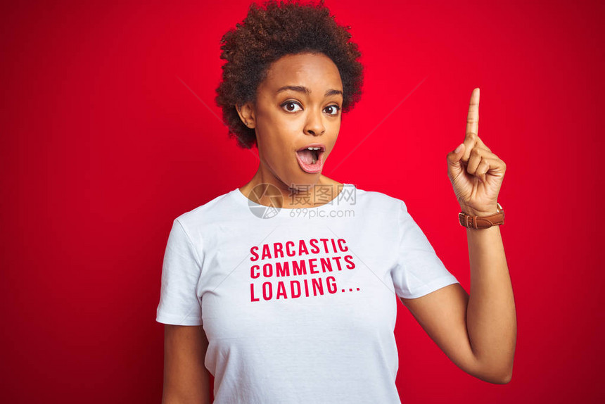 身穿讽刺评论T恤的非裔美国女在红色孤立背景上与成功的想法指手画脚退出并快乐第一图片