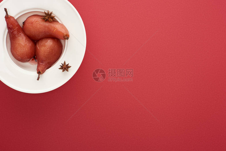 红底盘上茴香酒中美味梨的顶视图图片