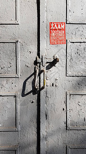 旧木制门用生锈的手柄和灰色剥皮涂漆图片