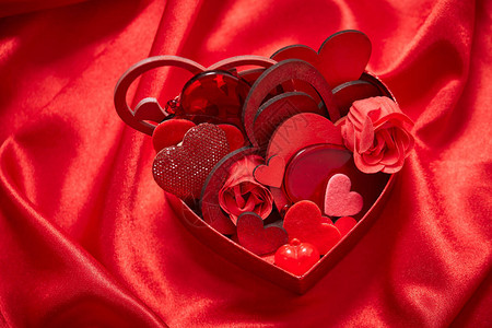 红色丝绸面料上带有心形的情人节装饰品图片