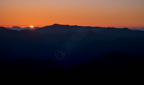 山顶的地平线上有橙色和的多彩日落图片