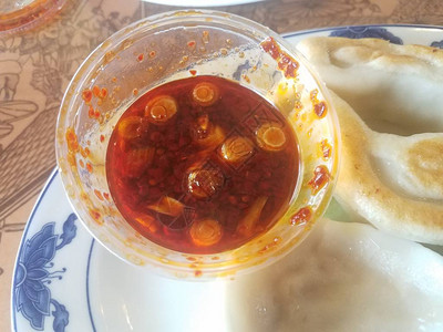 盘子上的饺子或锅贴配辣红油蘸酱图片