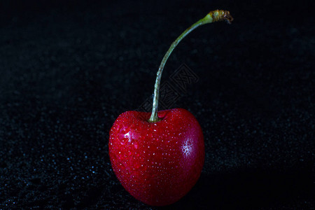 带水滴的红樱桃黑色背景上的樱桃图片
