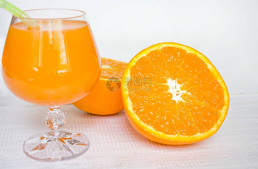 玻璃果汁橙汁和白木底的橙子维他命图片