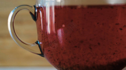 酿造在透明杯子的红茶特写镜头概念茶使沸水变红在木制背景上酿图片