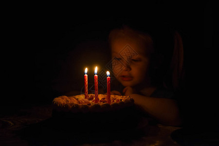 孩子仔细的看着生日蛋糕上的蜡烛图片