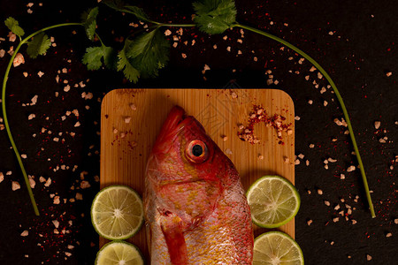 静物桌上放着生鲜鱼配上调味料和柠檬图片