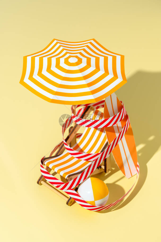 躺椅雨伞冲浪板和球都用保护信号胶带缠绕在沙滩上封闭海滩的概念微型简约构图片