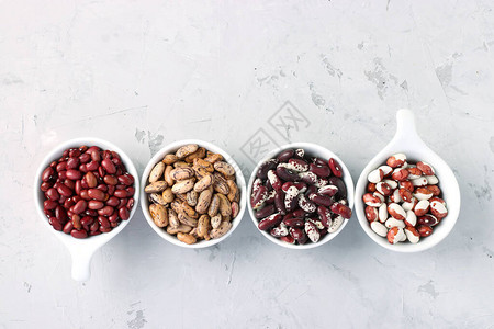 四种富含蛋白质的豆类位于灰色混凝土背景图片