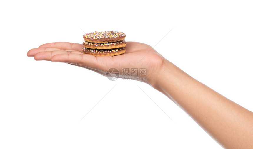 手握巧克力饼干洒在白色背景图片