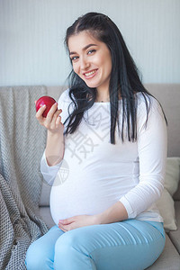 有苹果的可爱的孕妇期待女人拿着健康的食物夫人吃一个红苹果为怀孕提图片