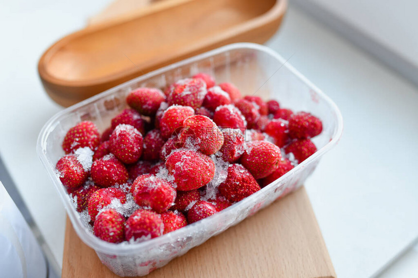 冷冻的草莓放在一个容器里冬天的草图片