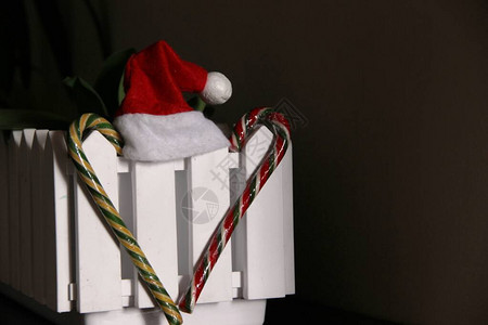 两只糖果甘蔗心形和红圣诞帽子白色装饰栅栏图片