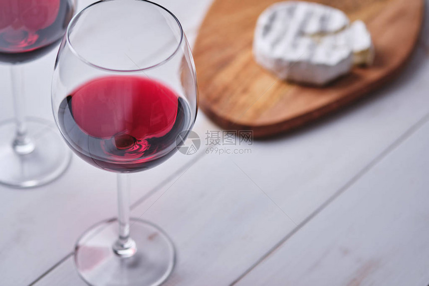 一杯白木桌上的红酒和黑白奶酪准备浪漫图片