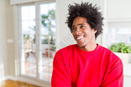 身穿散装红色运动衫的非裔美国人微笑着脸朝一边图片