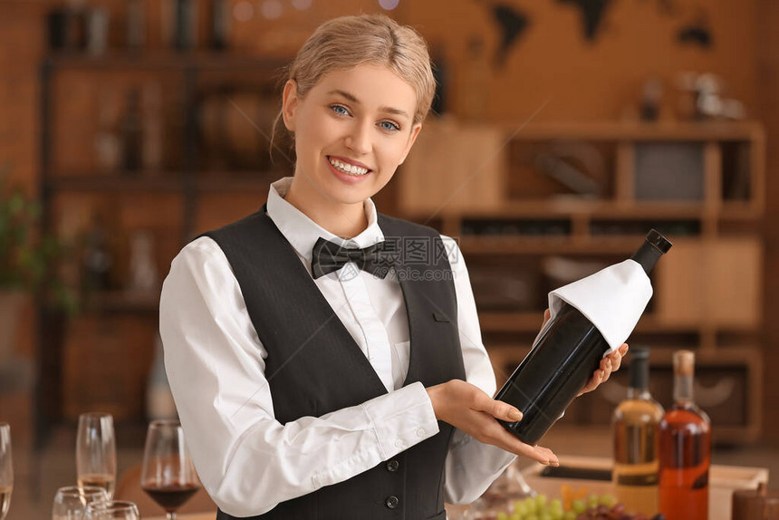 餐厅服务员端着一瓶酒图片