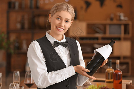 餐厅服务员端着一瓶酒图片